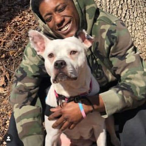 a white dog with its owner looking and smiling at the camera